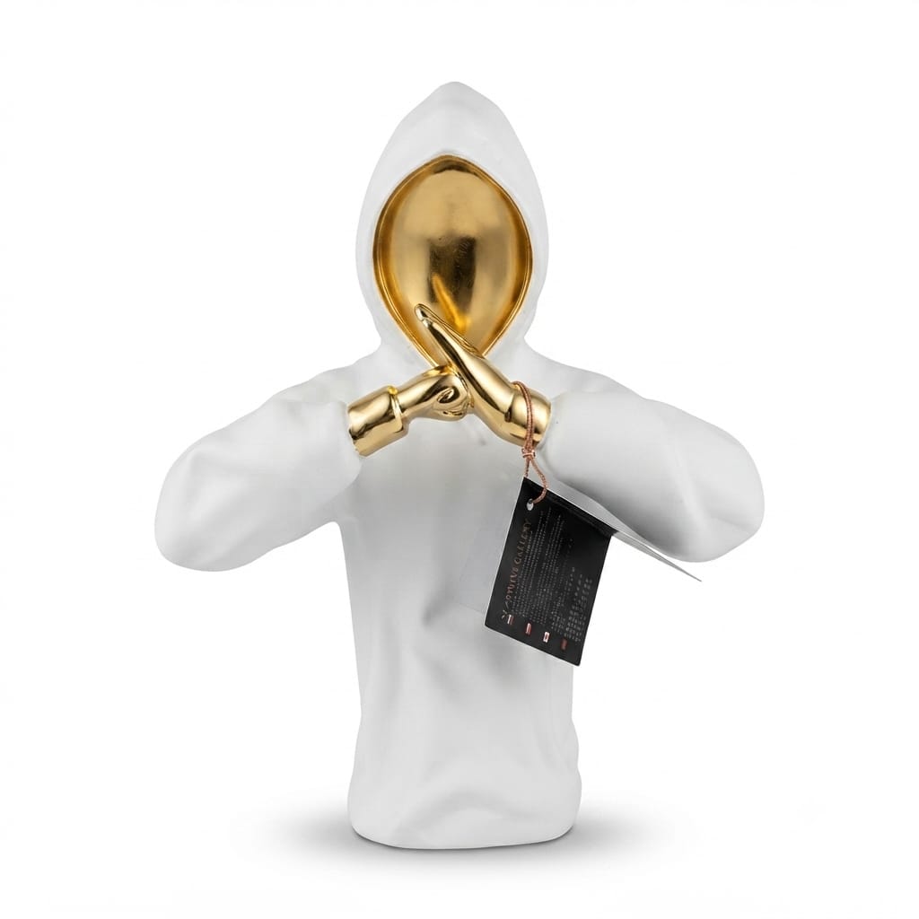 White hoodie-wearing abstract figurine with a glossy gold head and hands crossed in front