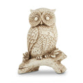 White owl figurine with intricate carved patterns perched on a tree branch
