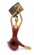 Red and gold abstract yoga figurine in a seated stretching pose with an attached product tag