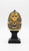 King Tutankhamun golden bust figurine featuring a blue and gold striped nemes headdress, beaded collar, and a mounted black pedestal