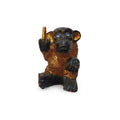 Black and gold-finish monkey figurine making a rude hand gesture