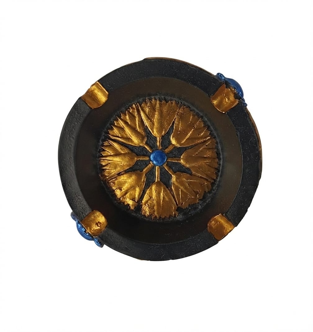 Dark grey and gold round ashtray featuring a central gold lotus flower design with a blue center stone