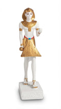 White and gold ancient Egyptian pharaoh figurine wearing a traditional nemes headdress, pleated kilt, and sandals on an inscribed base